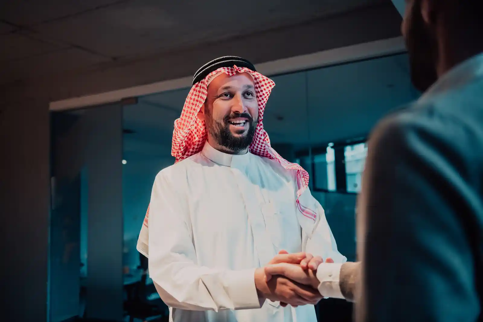 رجل أعمال سعودي يصافح شريكاً